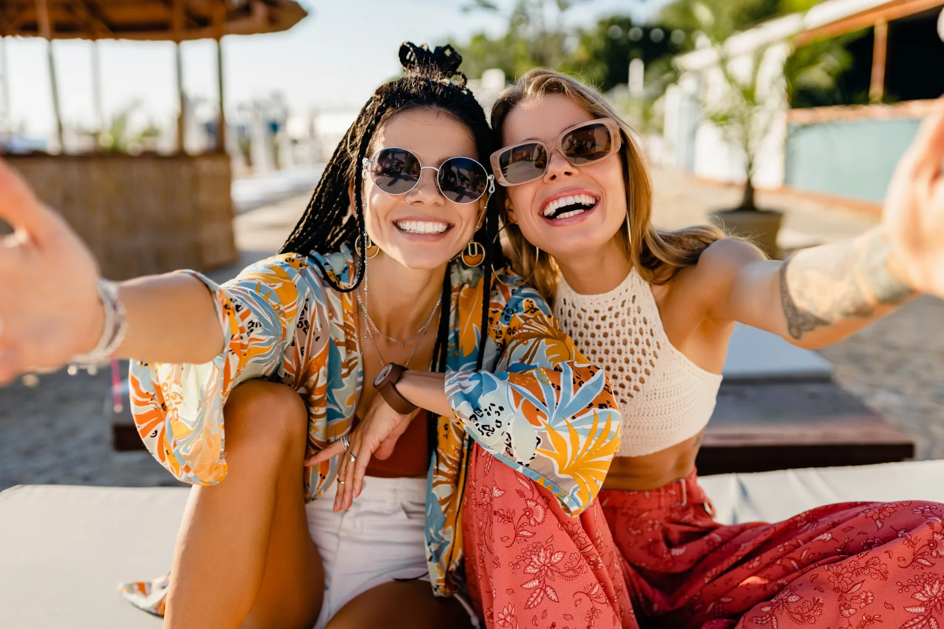 Two smiling friends wearing sunglasses outdoors