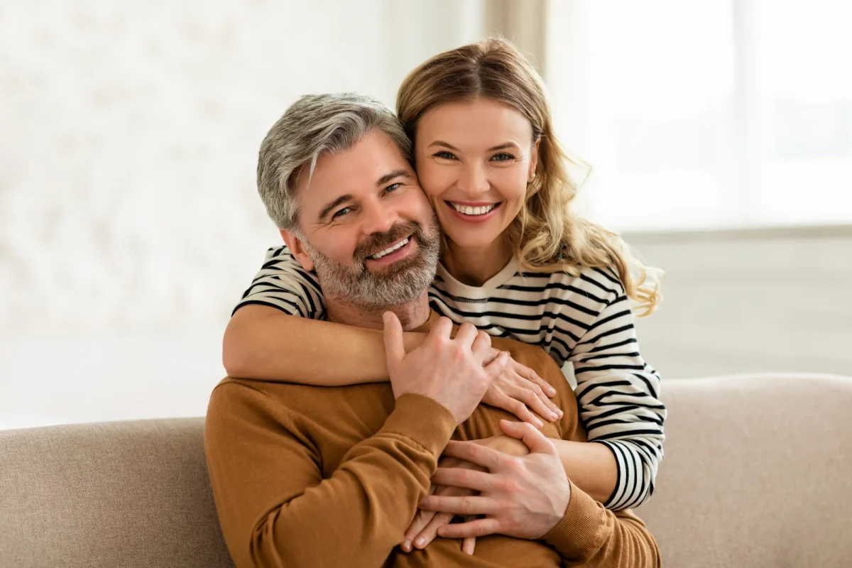 Smiling couple embracing on a sofa